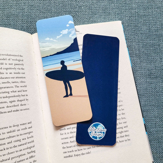 Illustrated bookmark of a surfer holding a surfboard and looking out to sea – surf design by Chloe Evans Designs