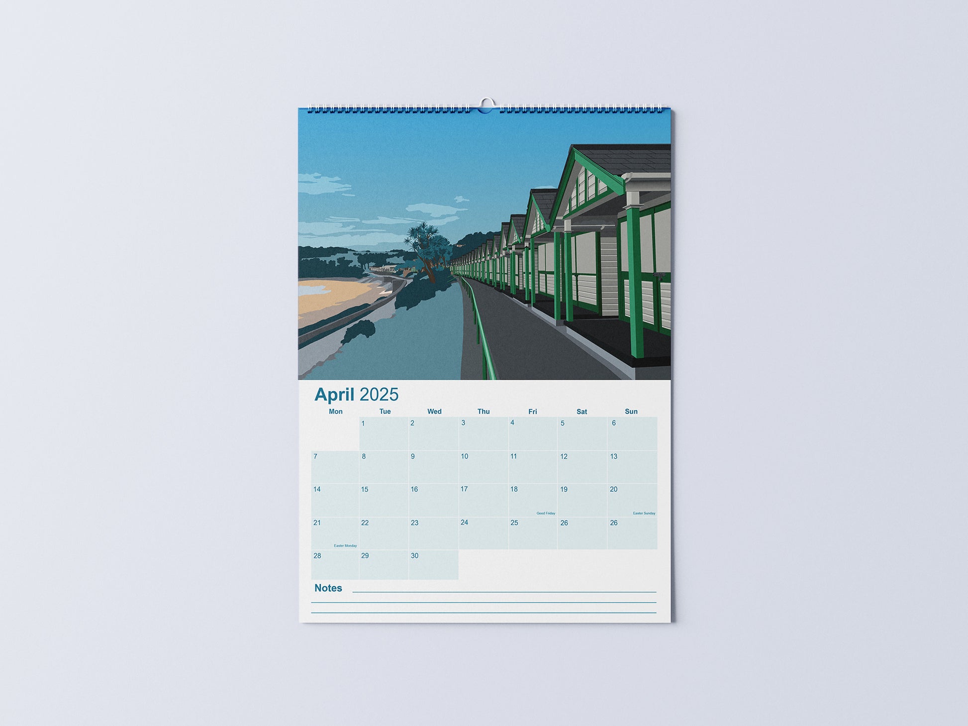 Digital mockup of an A3 coastal wall calendar, showing the April page with an illustration of the beach huts at Langland Bay in Gower.