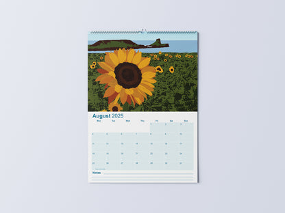 Digital mockup of an A3 coastal wall calendar, showing the August page with an illustration of sunflowers at Rhossili with Worm's Head in the background.