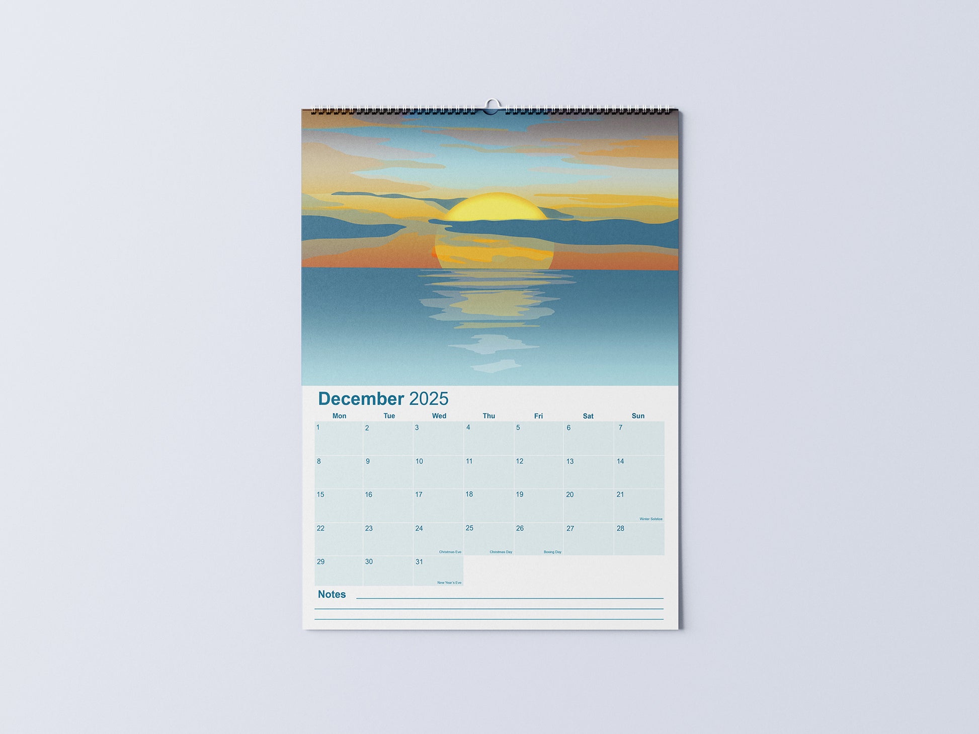 Digital mockup of an A3 coastal wall calendar, showing the December page with an illustration of an orange and blue sunset.