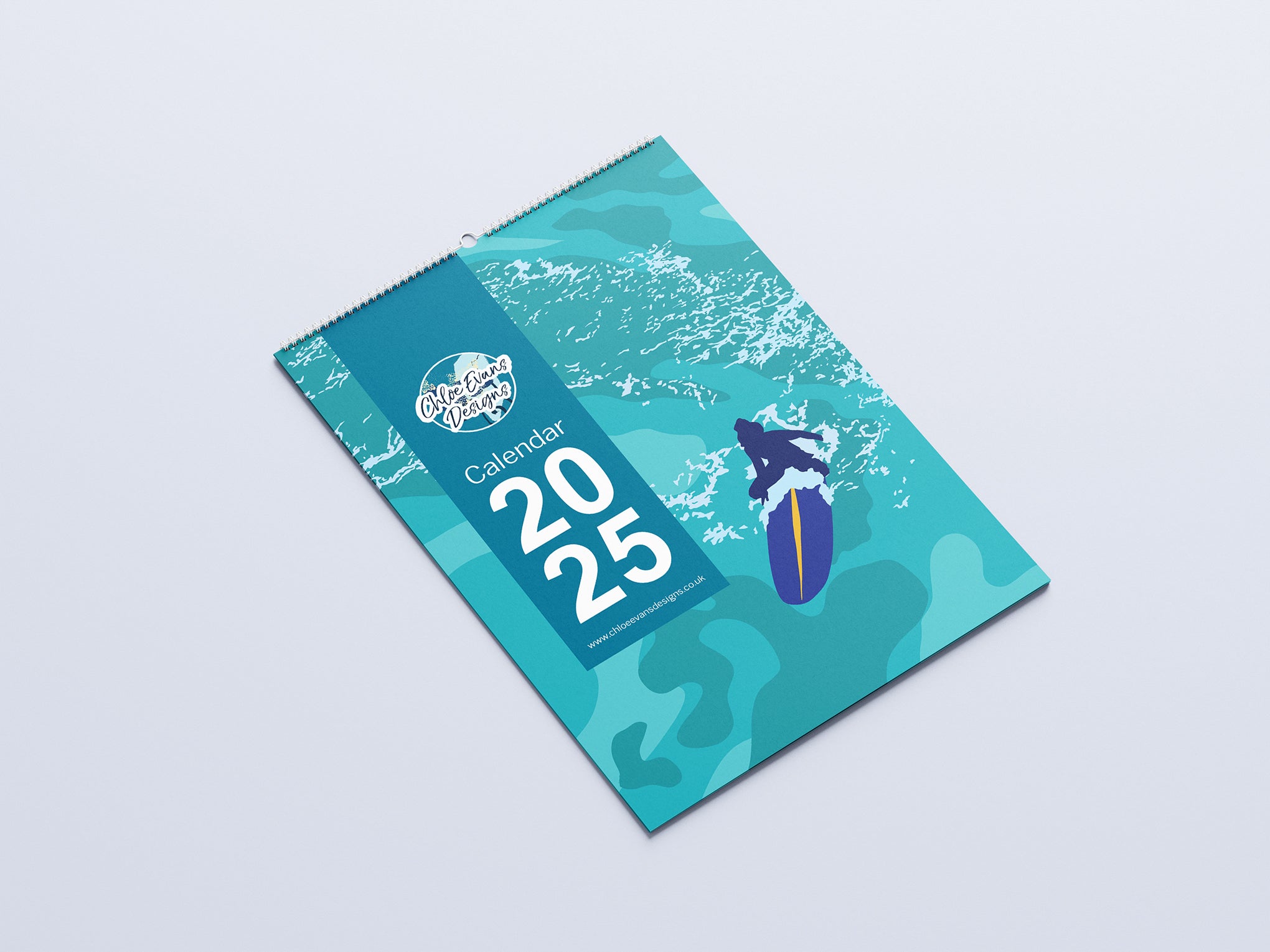 Digital mockup of an A3 coastal wall calendar, lay flat on a surface.