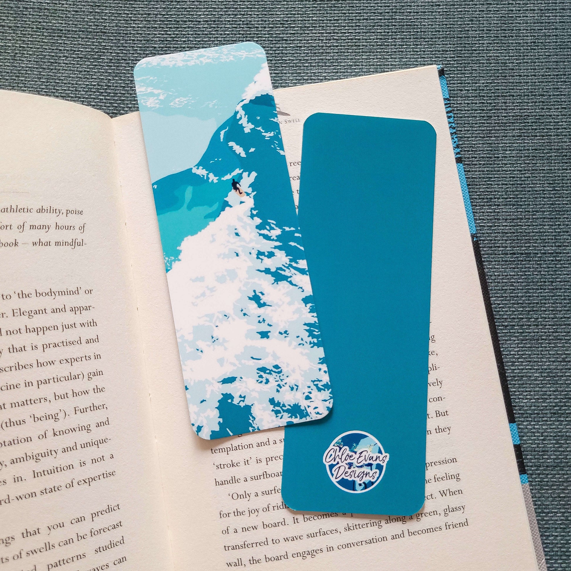Bookmark featuring a surfer riding a wave with white water splashing around – surf design by Chloe Evans