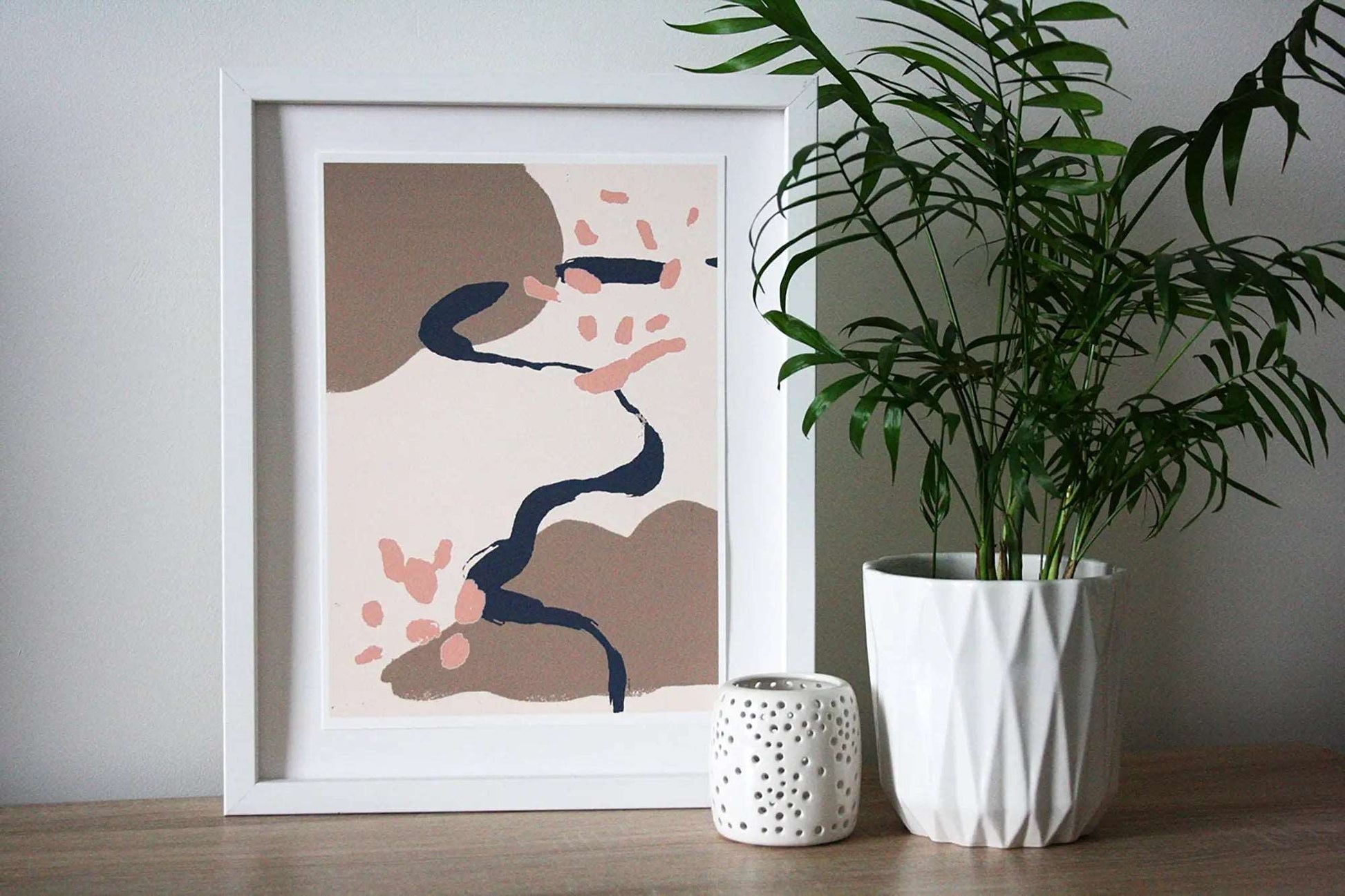 Photo of dusky pink, brown and blue Coastal Journey 15 abstract A4 print in white frame with white tealight holder and house plant