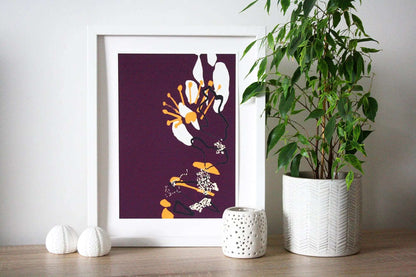 Photo of purple and yellow Coastal Journey 6 abstract A4 print in white frame, surrounded by white home accessories and house plant