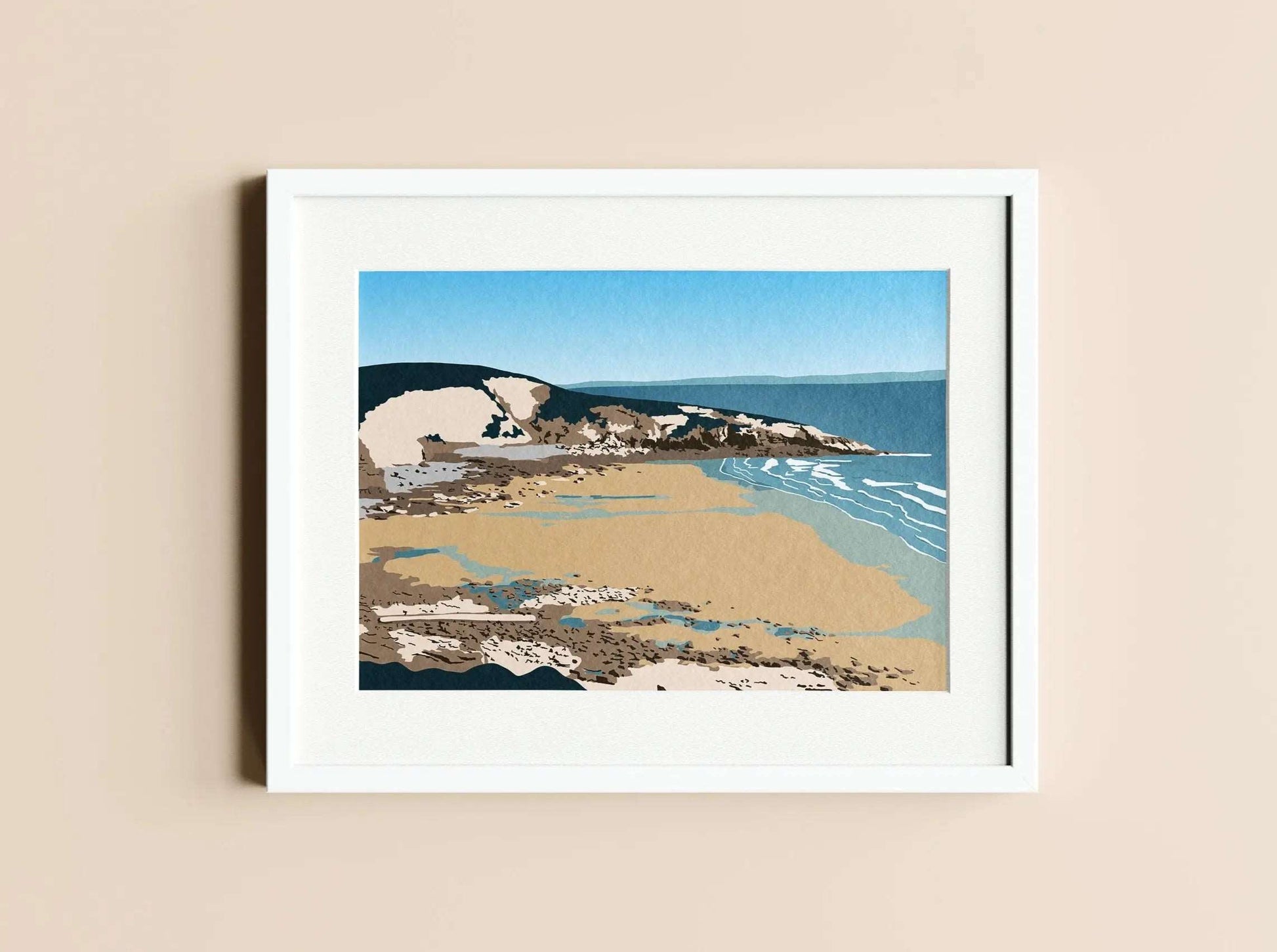 A green, blue and brown print of Dunraven bay, in a white photo frame on a cream wall