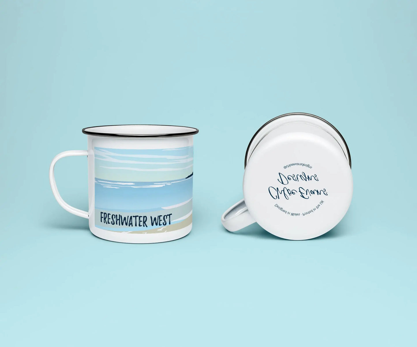 A mock up of a white enamel mug from two perspectives; one of the mug on its side looking at the bottom of the mug and the branded base stamp, and the other of the mug upright showing the print of Freshwater West beach, all on a light blue background.