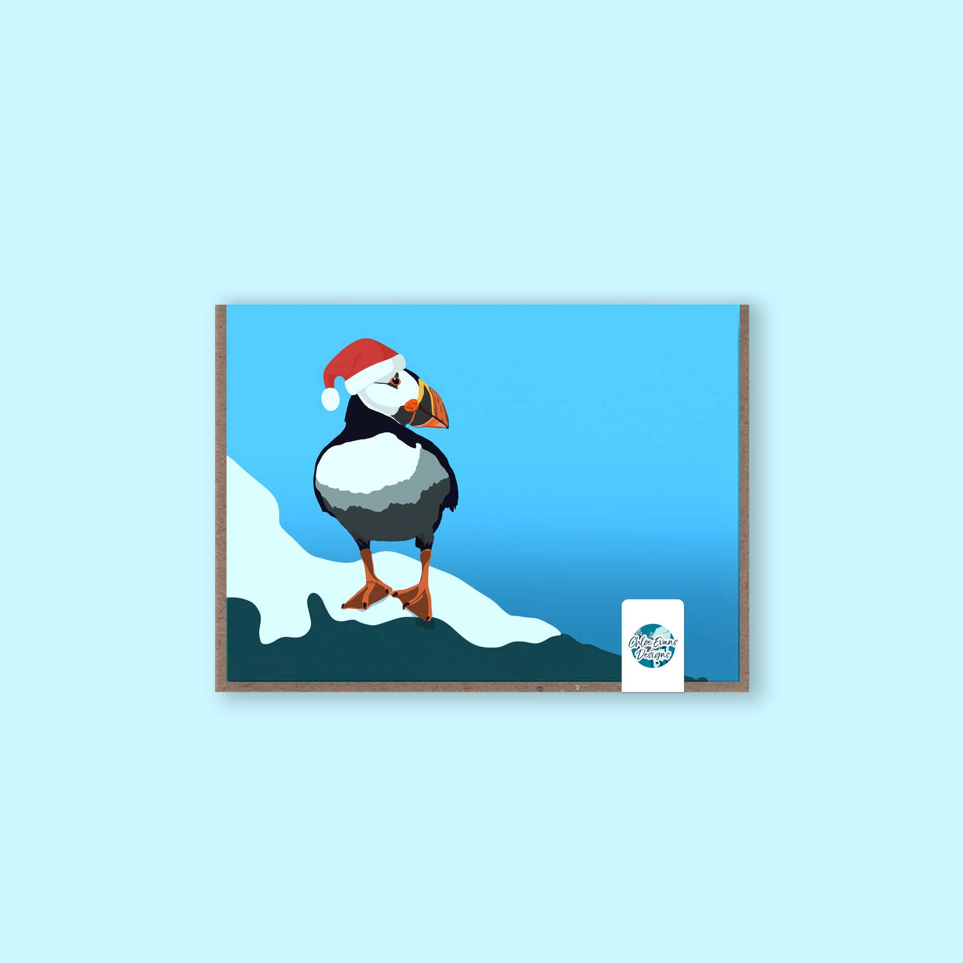 Christmas greeting card of a puffin wearing a Santa hat