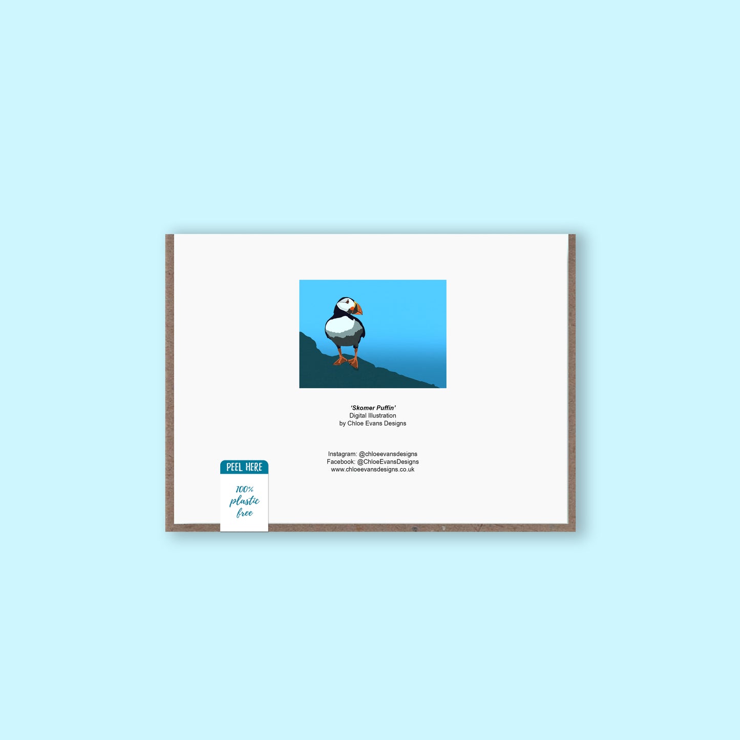 A mockup of a the back of a greeting card showing the illustration of a puffin that is on the front and business details, with a brown envelope behind and plastic-free packaging sticker, on a light blue background.