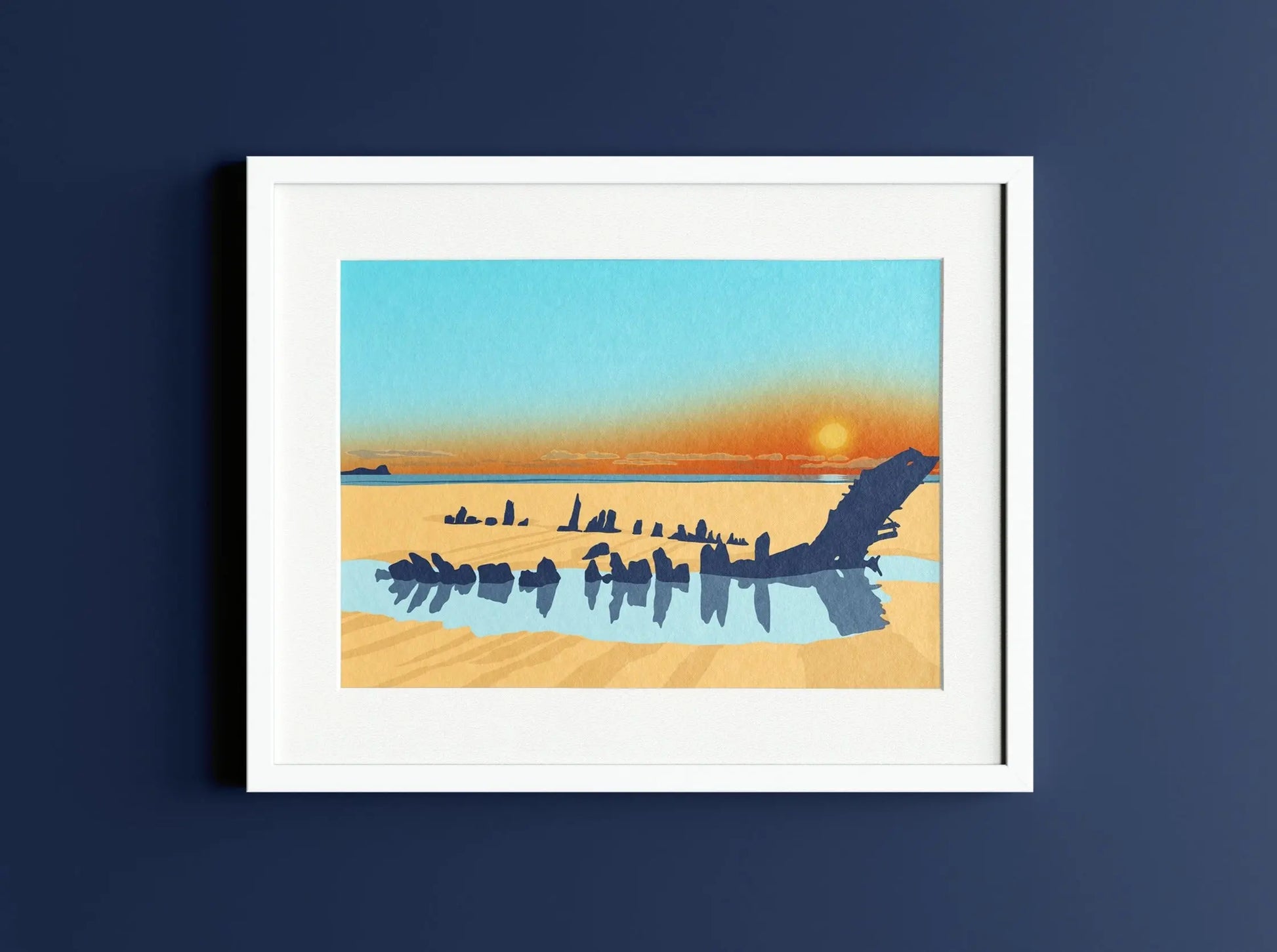 Digital mockup of blue and orange Helvetia Shipwreck Rhossili sunset print in white frame on dark blue wall background