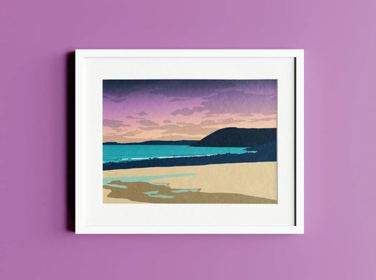 A purple, blue and cream print of Manorbier beach in a white photo frame on a purple wall