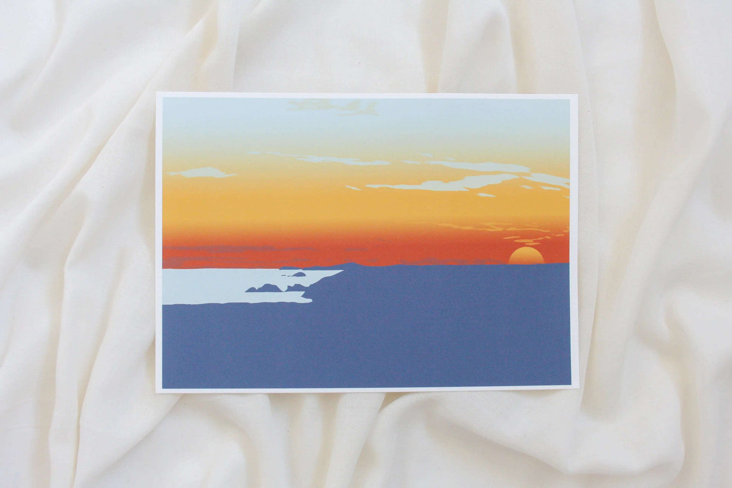 Photo of red, yellow and blue Newgale sunset illustration print on cream fabric backdrop.