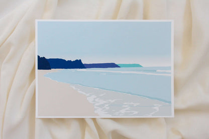 Photo of blue Oxwich beach illustration print on cream fabric backdrop.