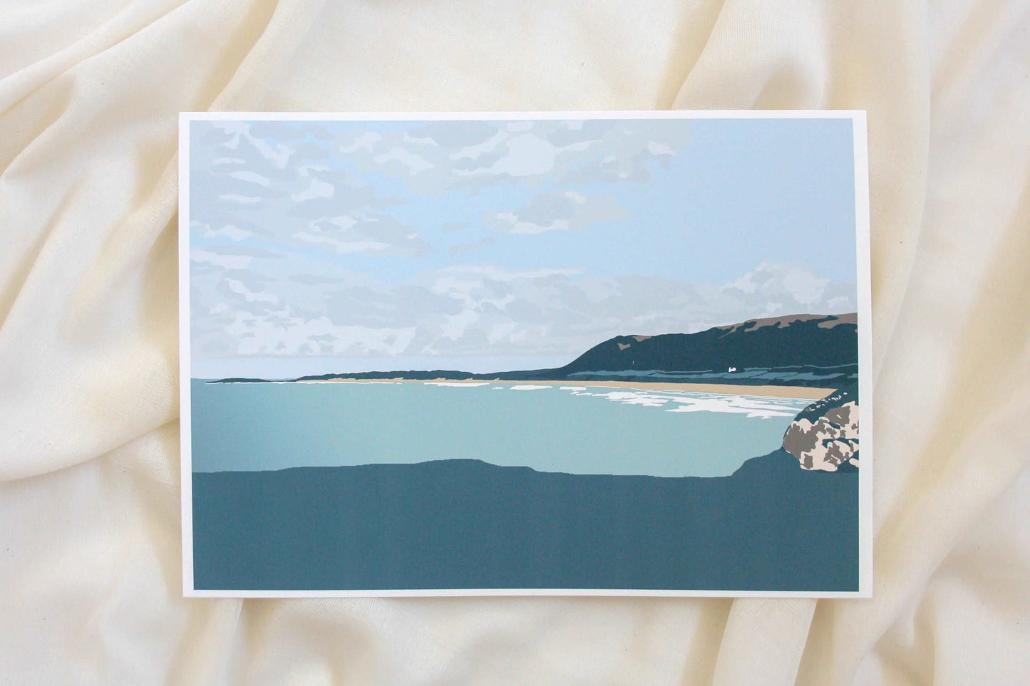 Photo of green Rhossili beach illustration print on cream fabric backdrop