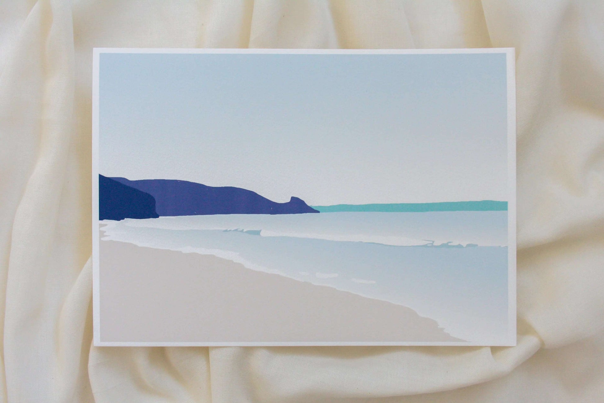 Photo of blue and turquoise Newgale Beach illustration print in cream fabric backdrop