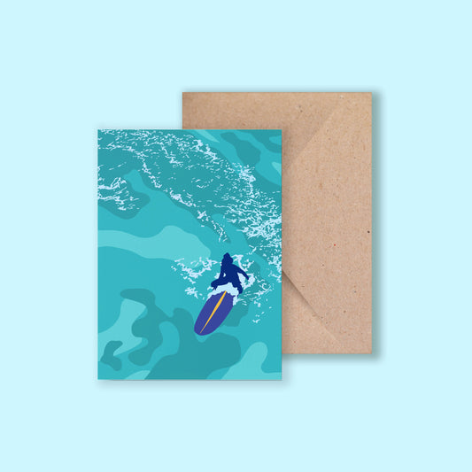 Greeting card featuring a woman sitting on a surfboard in open water, titled Serenity, illustrated by Chloe Evans Designs with a recycled kraft envelope