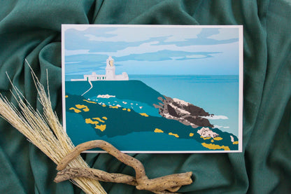 Photo of Strumble Head lighthouse on green fabric backdrop with driftwood and pampas grass