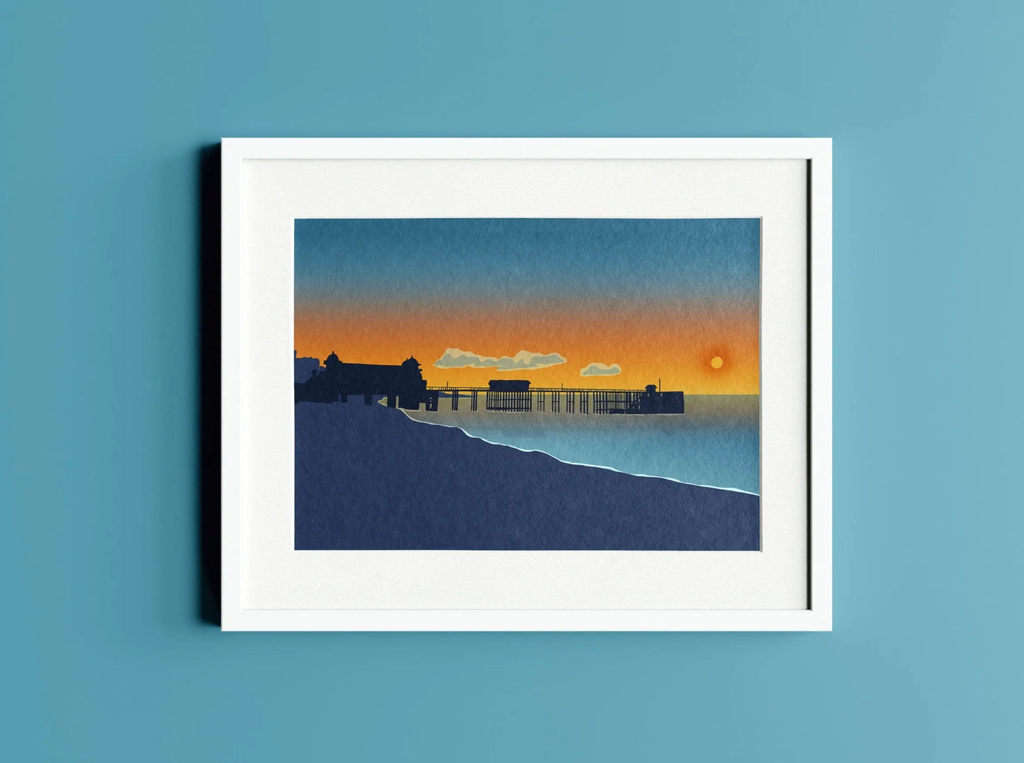 Blue and orange illustration of sunrise over Penarth Pier in white frame on a blue wall