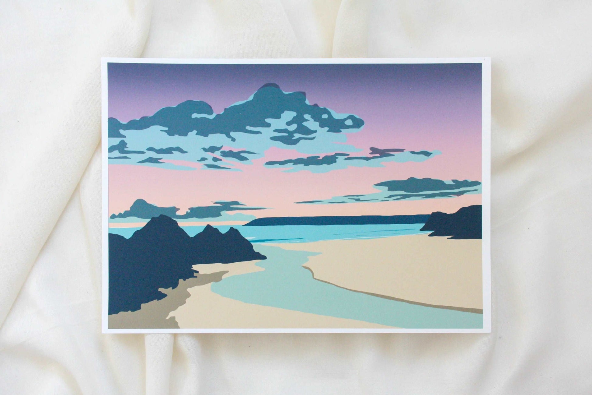 Photo of purple and blue Three Cliffs Bay sunset print on cream fabric backdrop