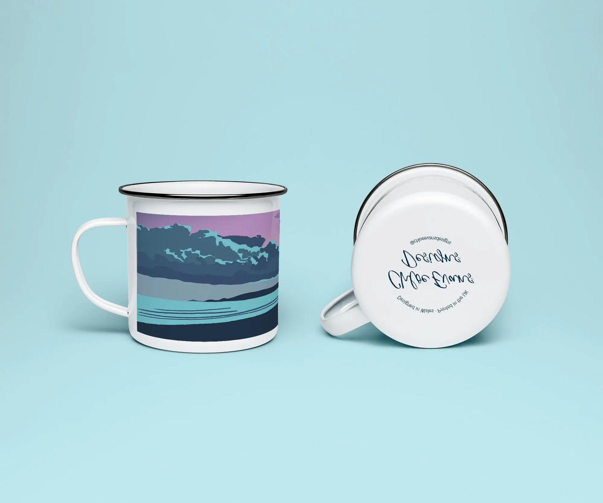 A mock up of a white enamel mug from two perspectives; one of the mug on its side looking at the bottom of the mug and the branded base stamp, and the other of the mug upright showing the print of an purple, orange, and blue beach scene, showing Swansea bay at sunset, all on a light blue background.