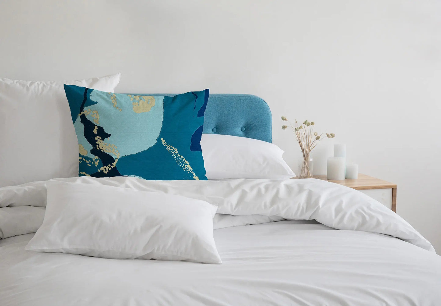 Digital mockup of 45cm teal and blue abstract printed cotton handmade cushion in white bedroom