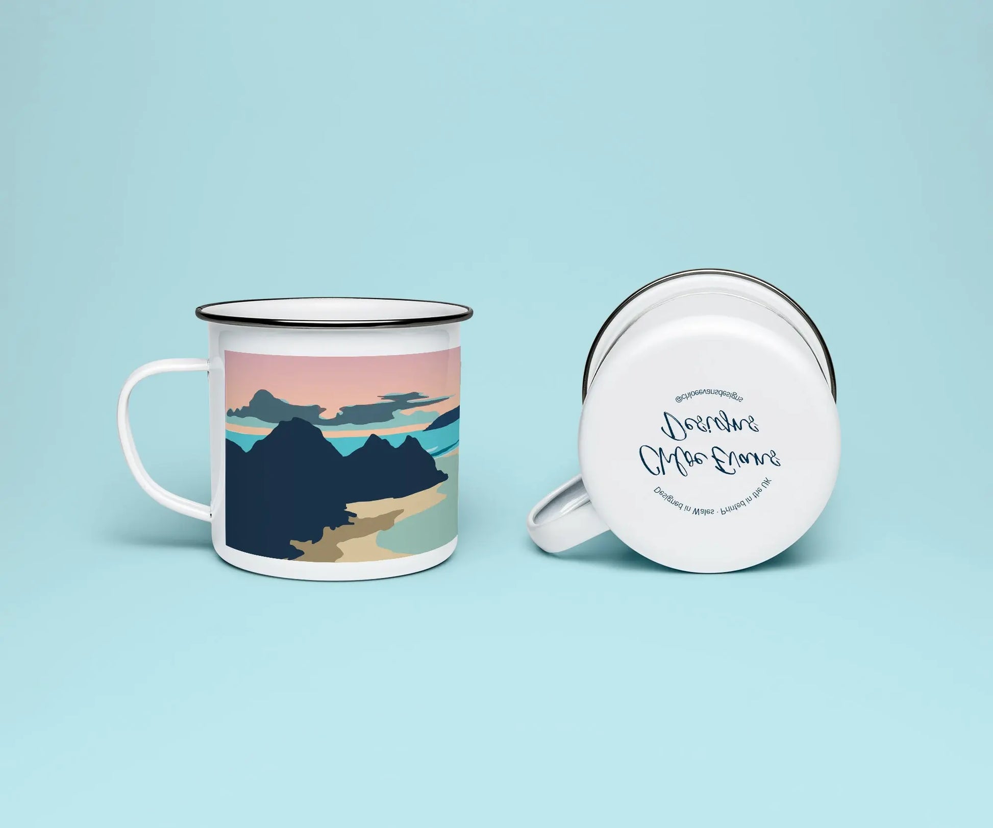 A white enamel mug from two perspectives: one of the mug on its side showing the branded base stamp on the bottom of the mug, and the other of the mug upright showing the blue, pink and orange sunset illustration of Three Cliffs bay at sunset; all on a light blue background.